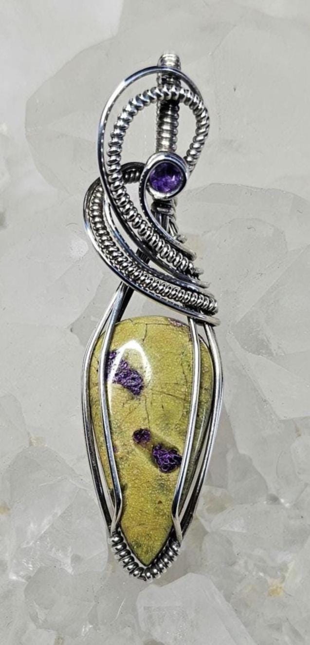 Atlantisite accented with a faceted Amethyst. Wrapped in Sterling Silver