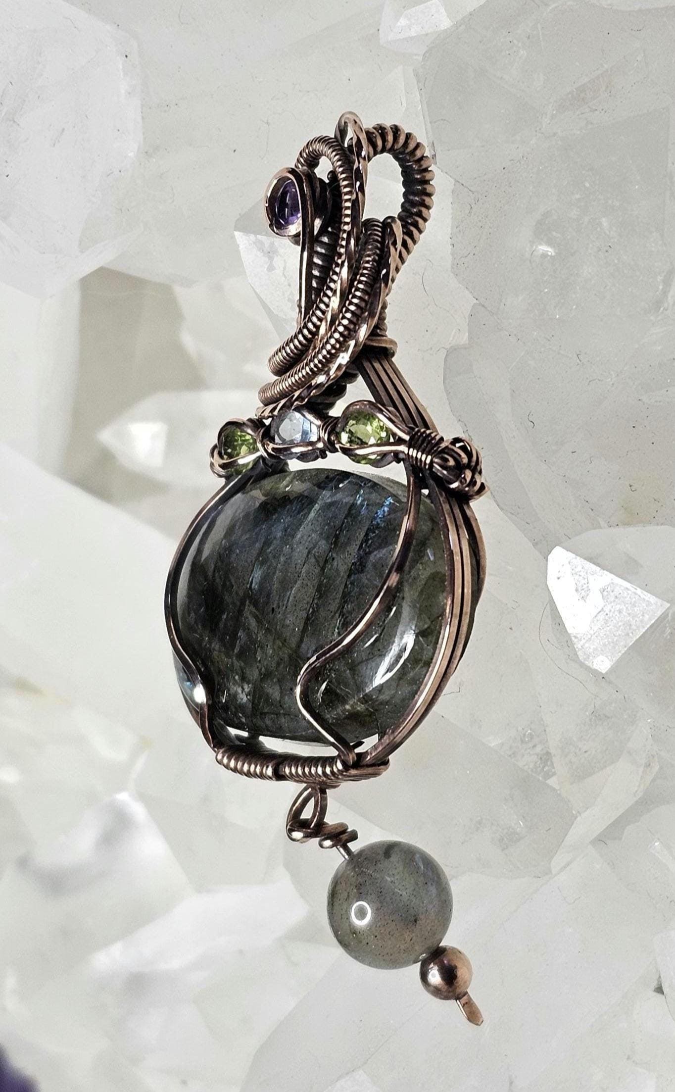 Labradorite, accented with a Amethyst at the bail and 2 Peridots and a Swiss Blue Topaz.