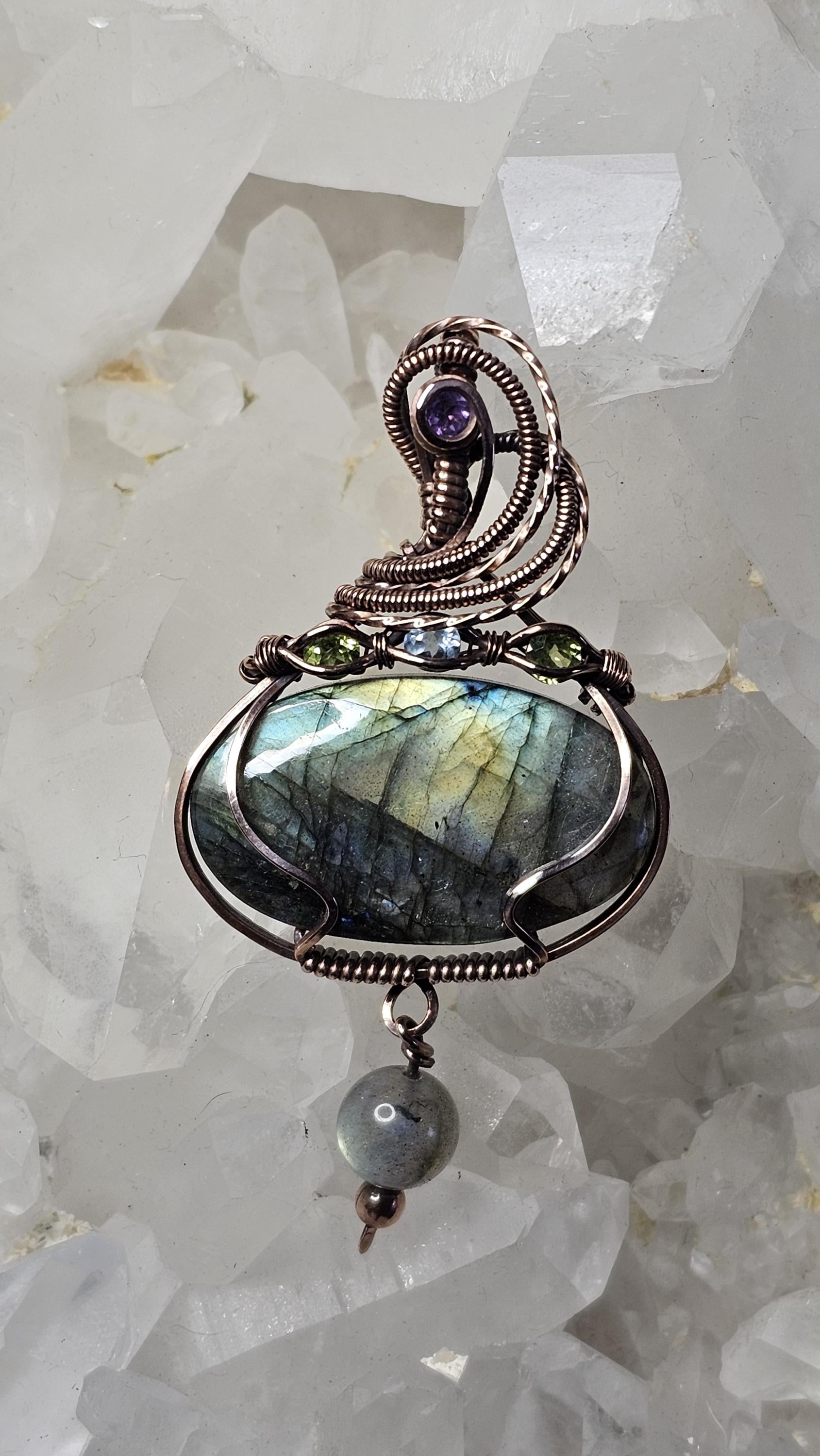 Labradorite, accented with a Amethyst at the bail and 2 Peridots and a Swiss Blue Topaz.